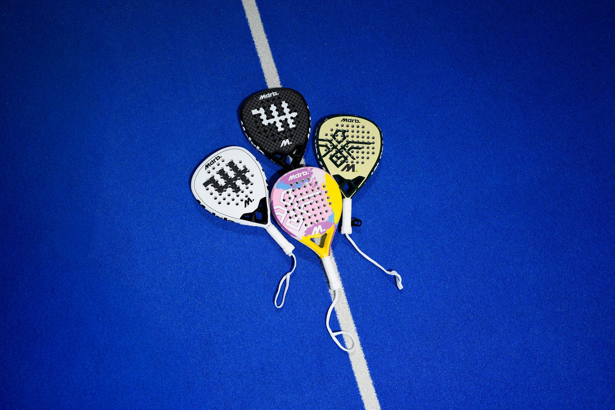 MDRB padel racket collection laid out on a court line